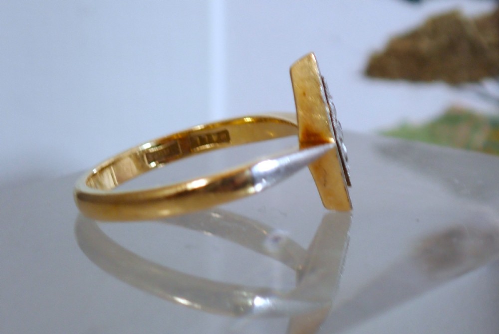 An Art Deco ring featuring a diamond-shaped lozenge motif set with four diamonds in platinum on an 18ct yellow gold band. View V
