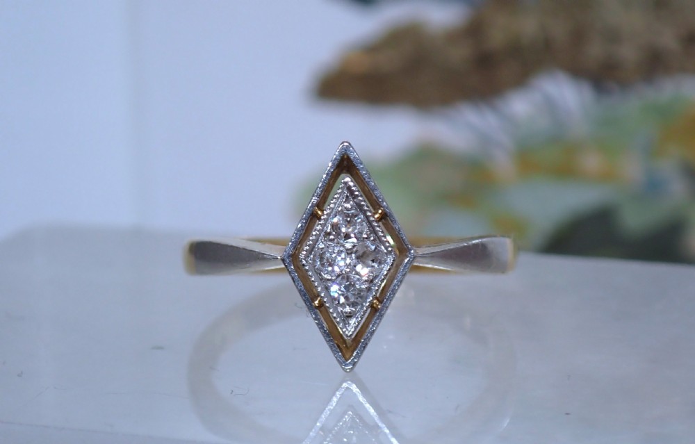 An Art Deco ring featuring a diamond-shaped lozenge motif set with four diamonds in platinum on an 18ct yellow gold band. View VII