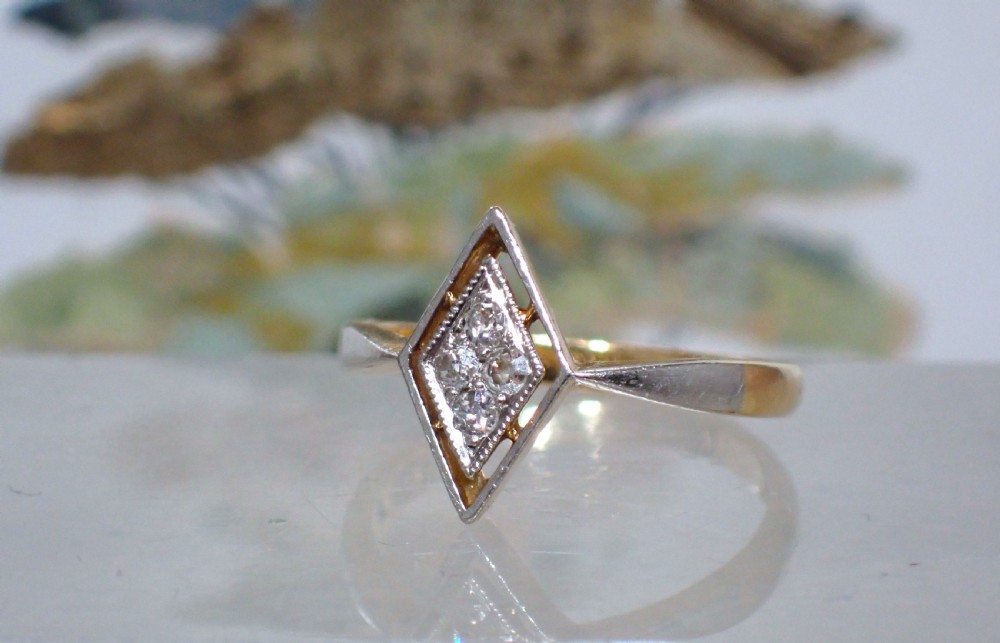 An Art Deco ring featuring a diamond-shaped lozenge motif set with four diamonds in platinum on an 18ct yellow gold band. View VIII
