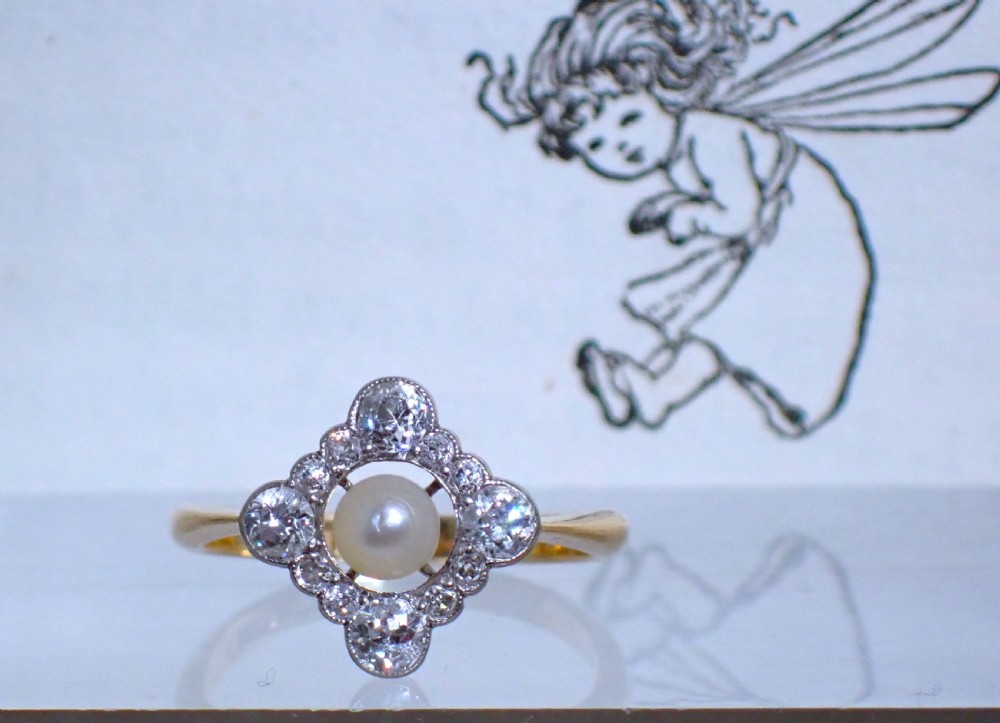 An antique Edwardian ring featuring a central natural pearl surrounded by a pierced diamond-set lozenge frame on an 18ct gold band. View II