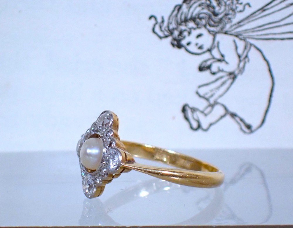 An antique Edwardian ring featuring a central natural pearl surrounded by a pierced diamond-set lozenge frame on an 18ct gold band. View III
