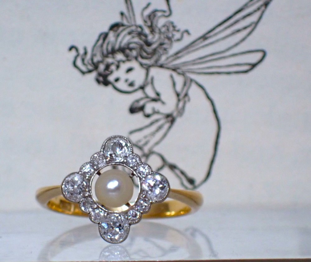 An antique Edwardian ring featuring a central natural pearl surrounded by a pierced diamond-set lozenge frame on an 18ct gold band. View IV