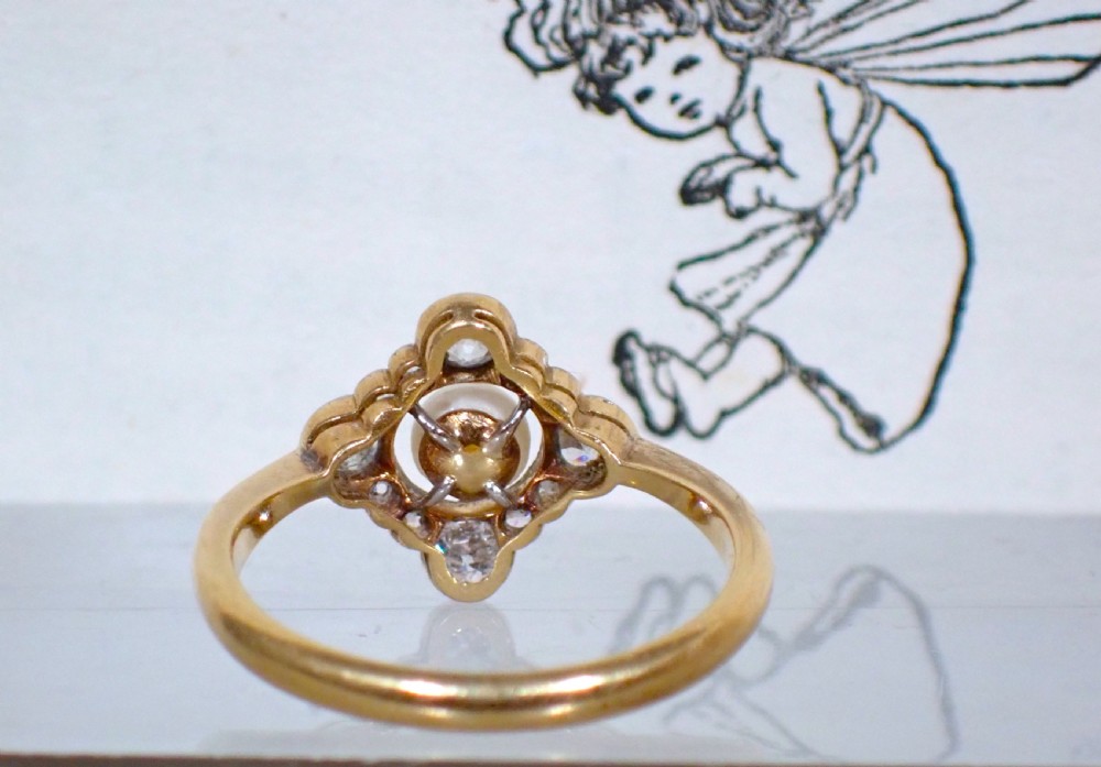 An antique Edwardian ring featuring a central natural pearl surrounded by a pierced diamond-set lozenge frame on an 18ct gold band. View VIII