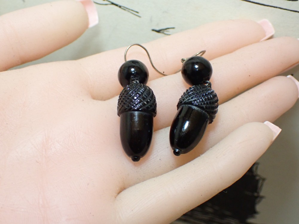 Pair of Victorian drop earrings featuring hand-carved black Whitby jet acorns beneath smooth round jet beads, fitted with 9ct gold ear wires. View V