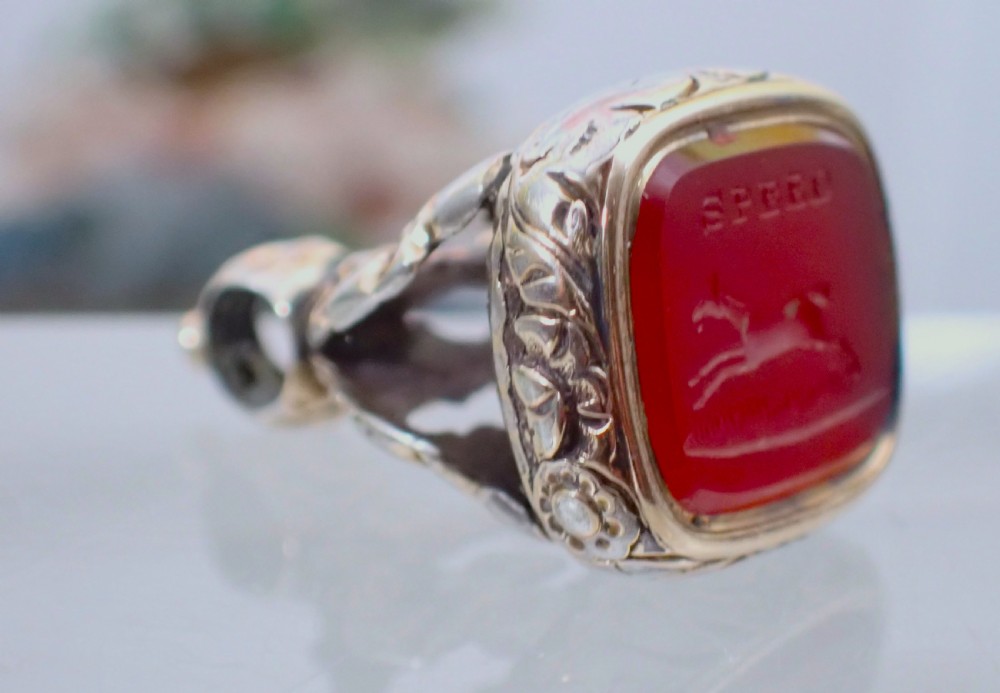 A Georgian gold cased fob seal featuring a carved red carnelian intaglio depicting a galloping horse under the engraved word SPEED. View II