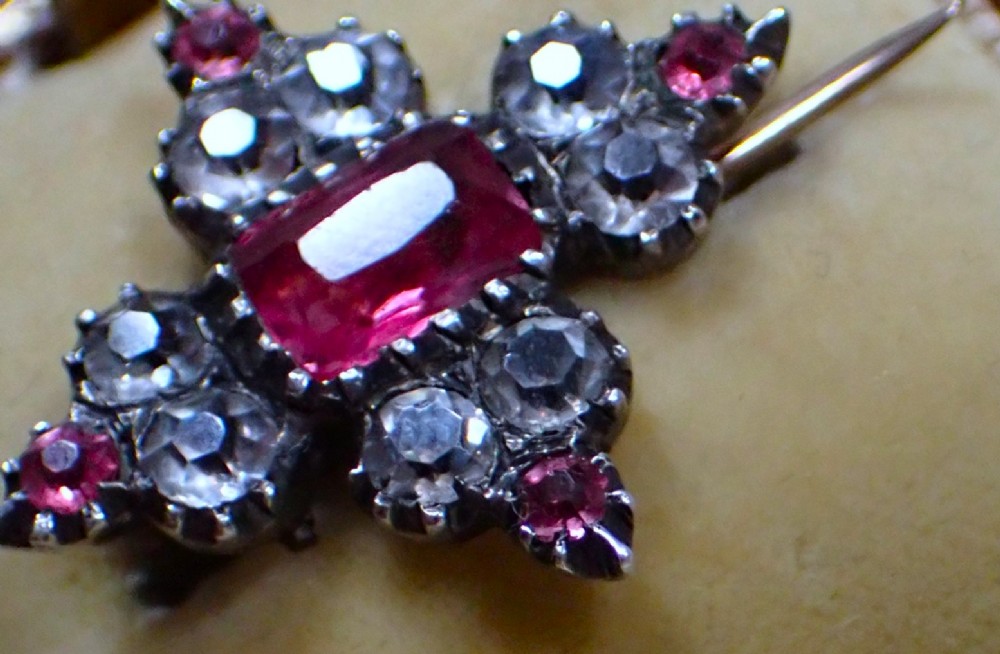 A cruciform Georgian brooch set with silver-topped black dot paste stones around a central rectangular pink ruby-coloured paste gem. View III