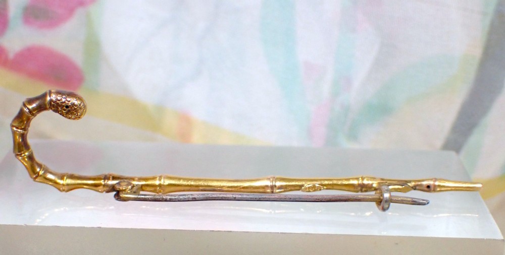 An Edwardian 15ct yellow gold brooch rendered in the shape of a bamboo walking cane with a textured crook handle. View III