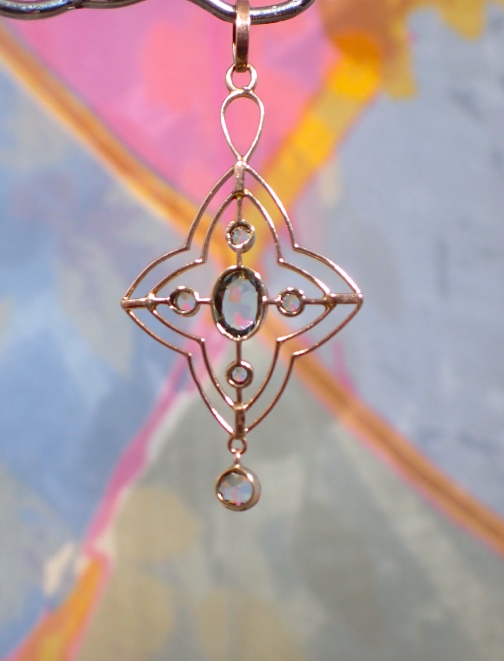 An openwork 9ct gold Edwardian pendant set with a central oval aquamarine, white sapphires, and a suspended aquamarine drop. View III
