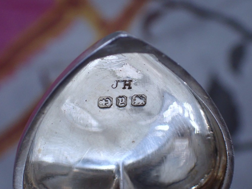 An open heart-shaped Victorian sterling silver sovereign holder showing an engine-turned internal spring mechanism and official hallmarks. View VII