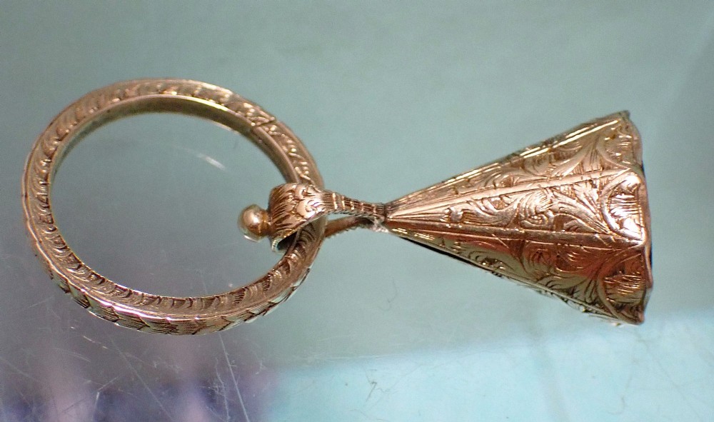 An antique 15ct gold conical fob seal featuring hand-engraved scroll motifs attached to a matching gold split ring. View V