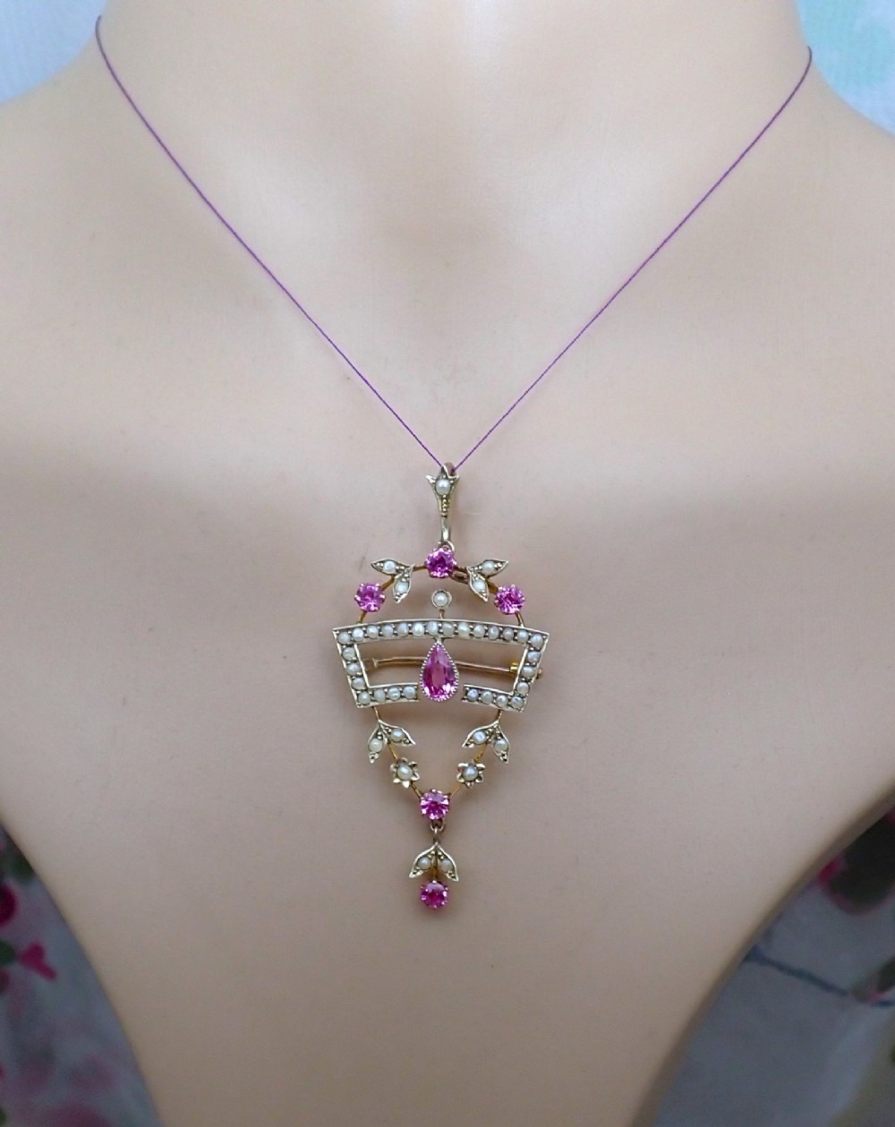 An Edwardian 15ct gold openwork pendant brooch set with natural pink tourmalines and seed pearls, featuring a central pear-cut gemstone drop. View II