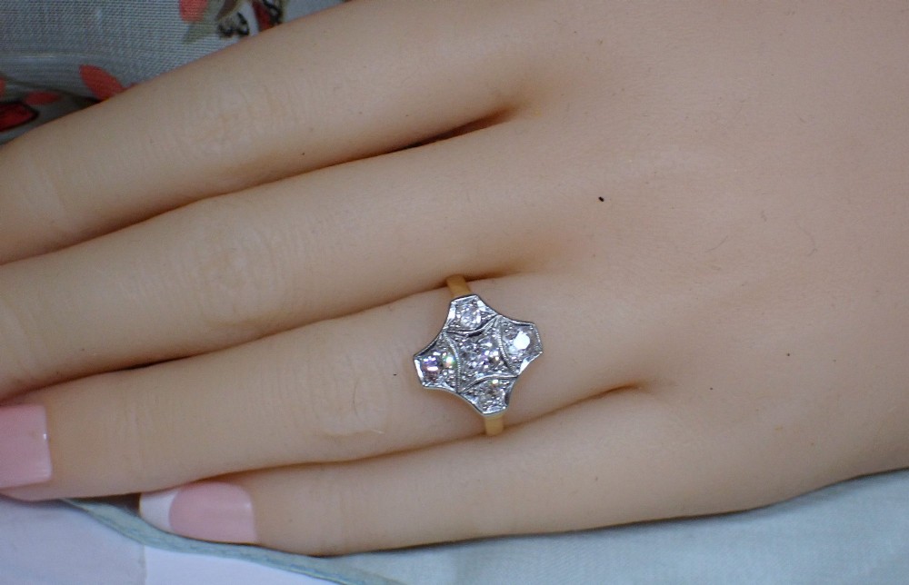 An Art Deco diamond ring featuring a geometric platinum plaque setting mounted on an 18ct yellow gold band. View II
