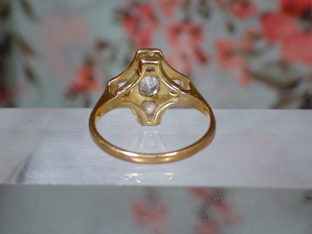 An Art Deco diamond ring featuring a geometric platinum plaque setting mounted on an 18ct yellow gold band. View V