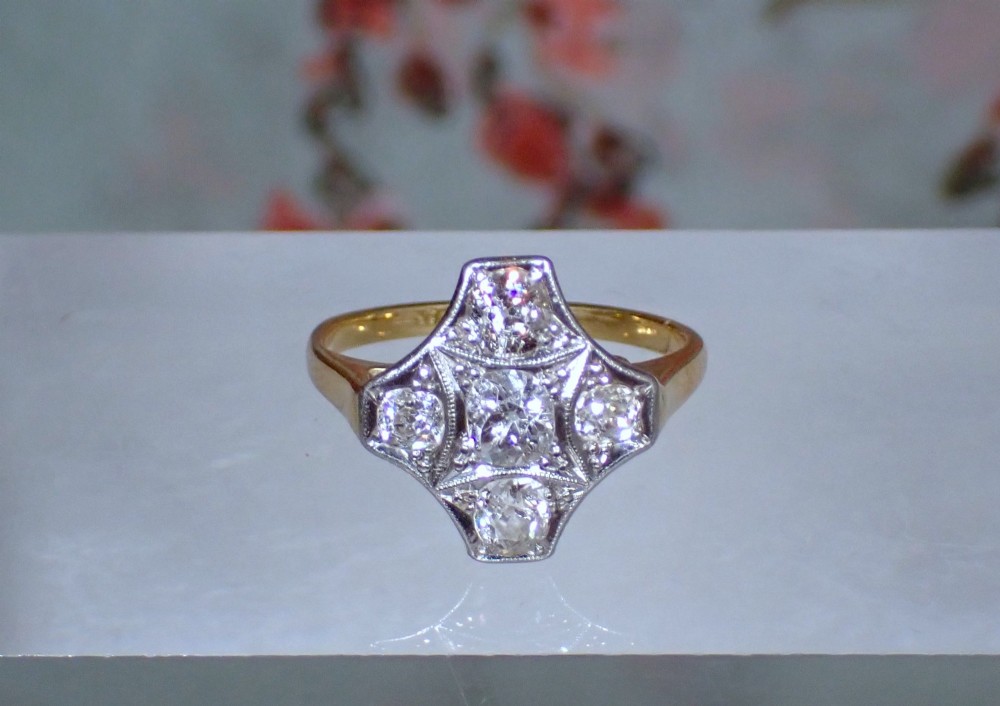 An Art Deco diamond ring featuring a geometric platinum plaque setting mounted on an 18ct yellow gold band. View VI