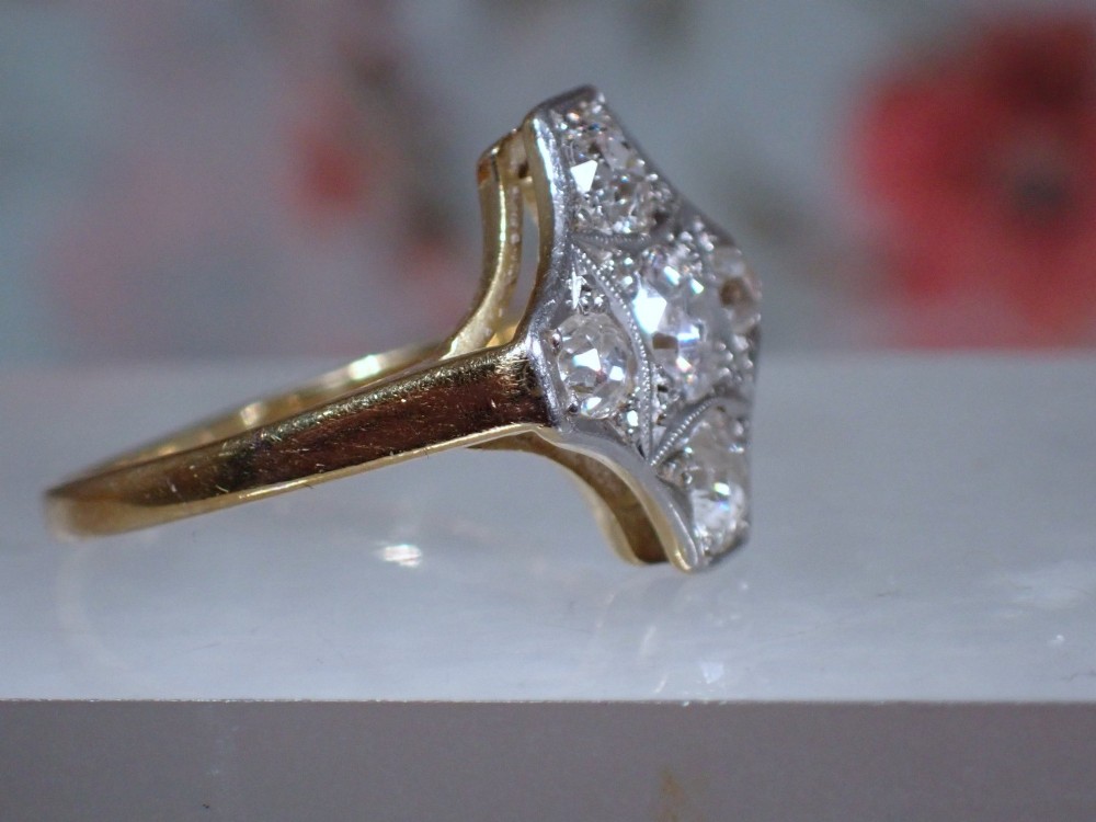 An Art Deco diamond ring featuring a geometric platinum plaque setting mounted on an 18ct yellow gold band. View VIII