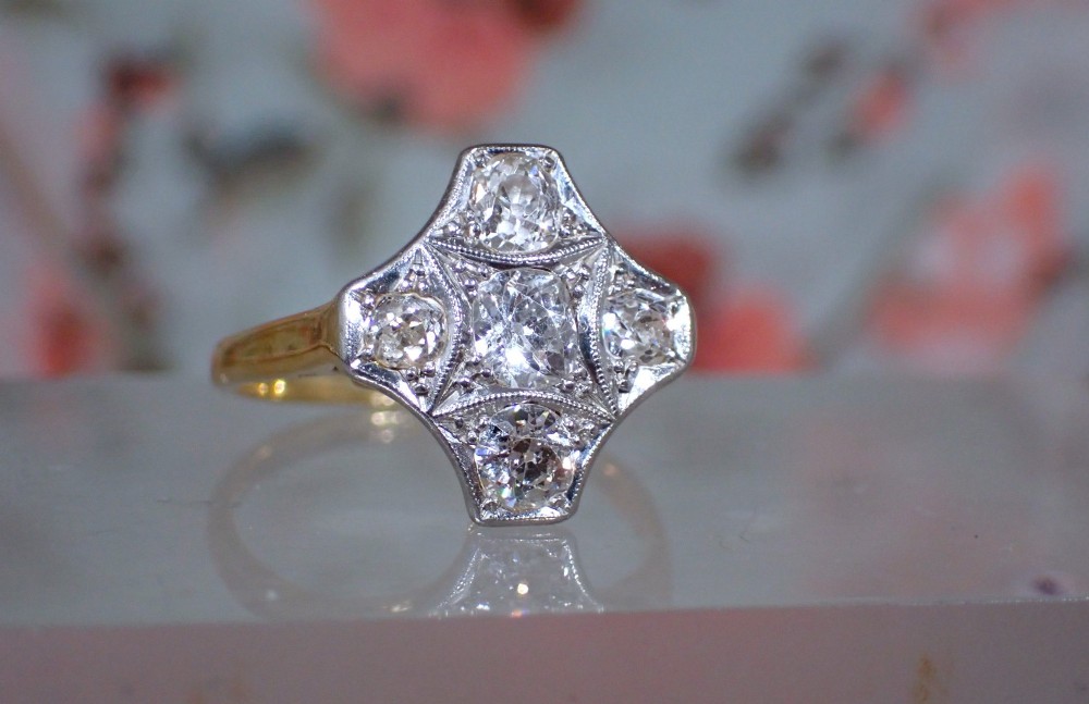 An Art Deco diamond ring featuring a geometric platinum plaque setting mounted on an 18ct yellow gold band. View X