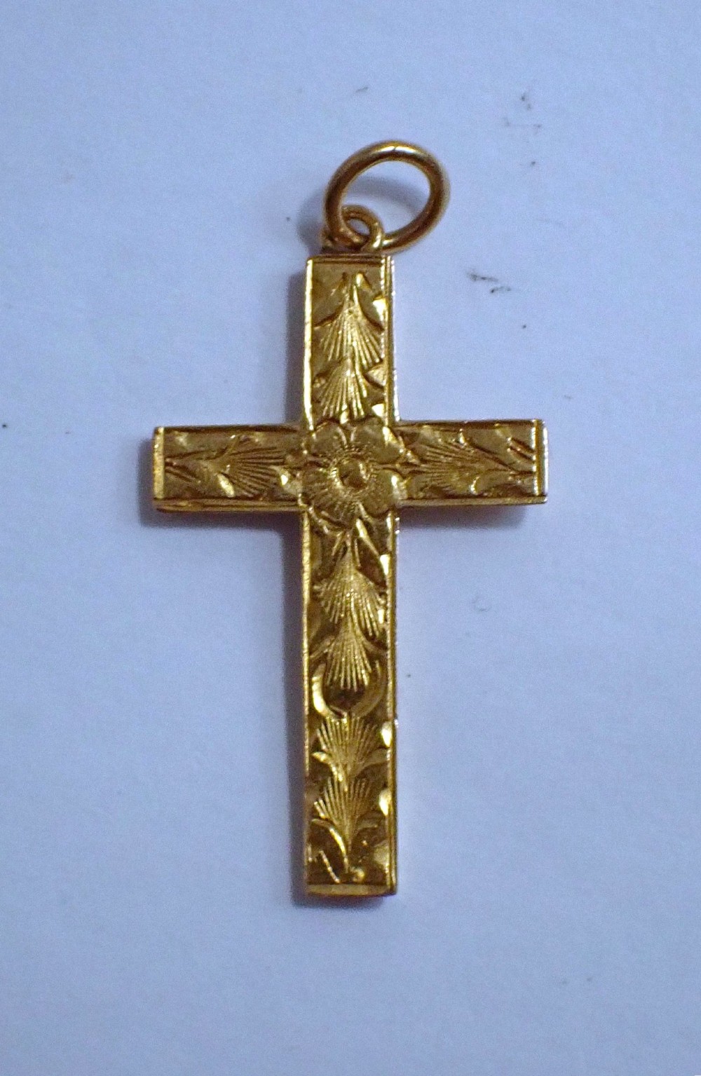 A Victorian 15ct yellow gold cross pendant featuring hand-engraved foliate patterns and a suspension ring at the top. View II