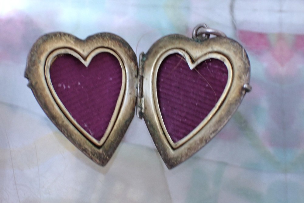 A heart-shaped silver locket featuring cobalt blue guilloche enamel decorated with a hand-painted floral rose garland motif. View V
