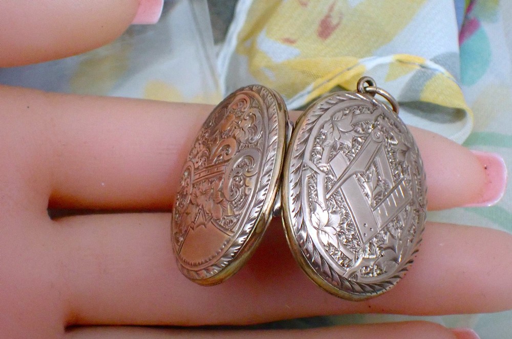 An oval Victorian rose gold back and front locket featuring intricate hand-engraved scrollwork and floral motifs with a top suspension loop. View III