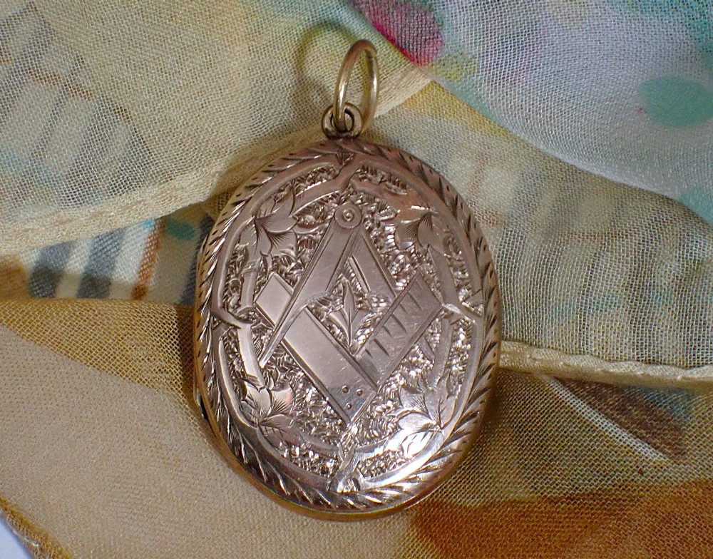 An oval Victorian rose gold back and front locket featuring intricate hand-engraved scrollwork and floral motifs with a top suspension loop. View IV
