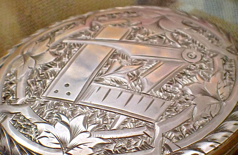 An oval Victorian rose gold back and front locket featuring intricate hand-engraved scrollwork and floral motifs with a top suspension loop. View V