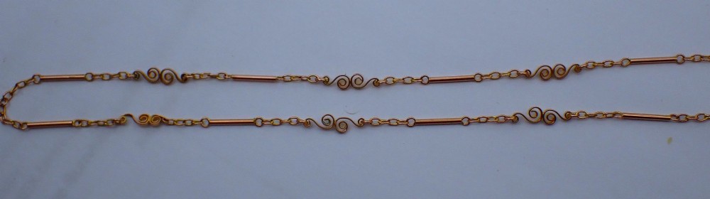 An antique Victorian 9ct rose gold chain composed of alternating cylindrical bar links and coiled wirework scrolls. View IV