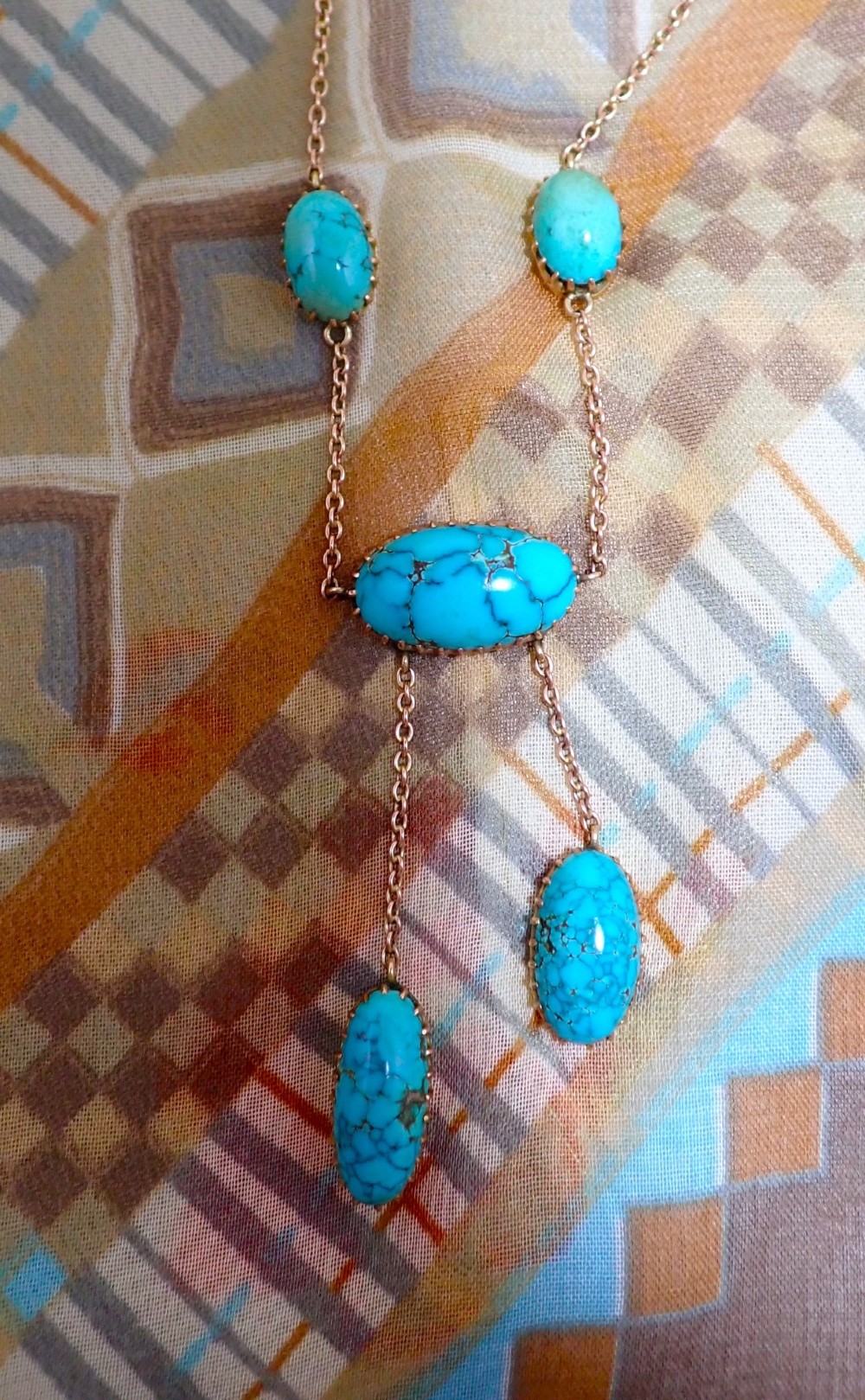 An Edwardian 9ct rose gold negligee necklace set with five oval matrix turquoise cabochons suspended on fine trace chains. View III