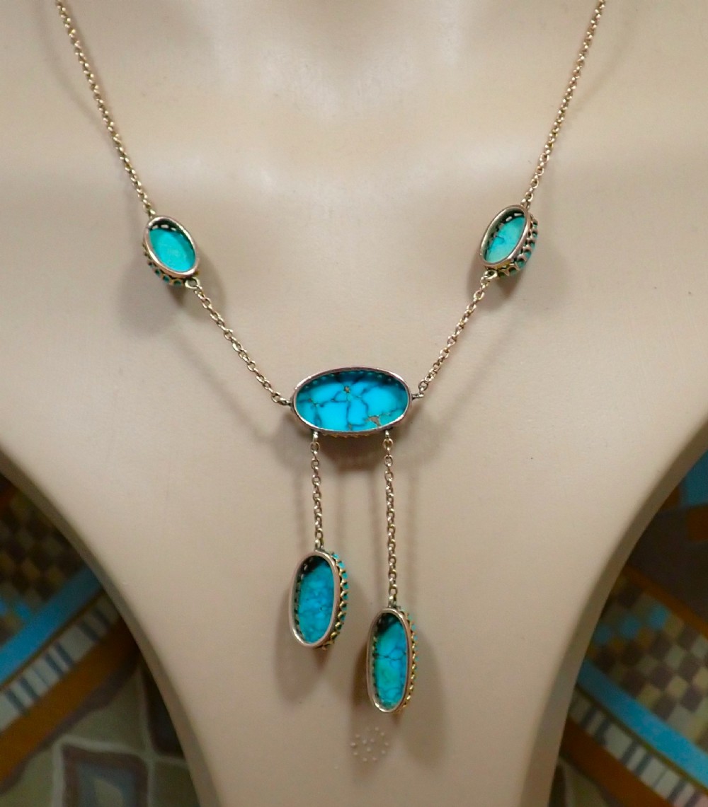 An Edwardian 9ct rose gold negligee necklace set with five oval matrix turquoise cabochons suspended on fine trace chains. View V