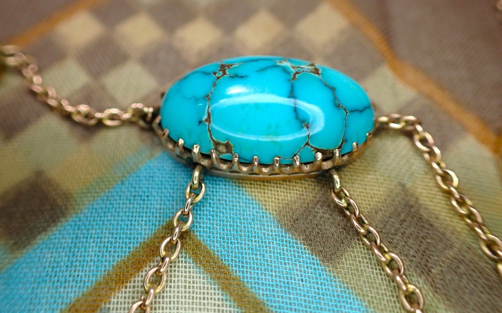An Edwardian 9ct rose gold negligee necklace set with five oval matrix turquoise cabochons suspended on fine trace chains. View VII