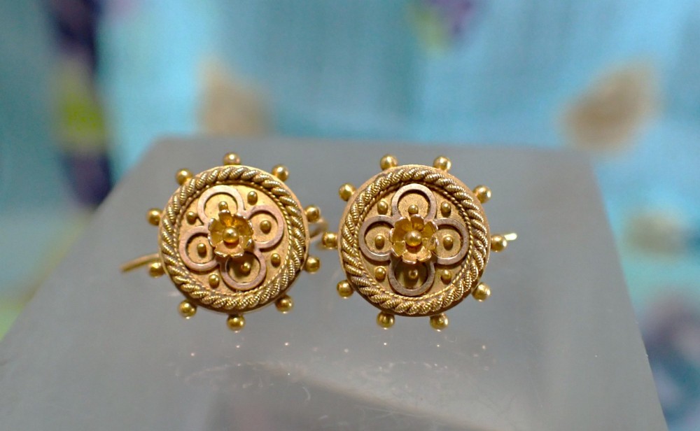 A pair of Victorian 15ct gold circular stud earrings featuring Etruscan Revival wirework, bead granulation, and a central floral rosette. View VI