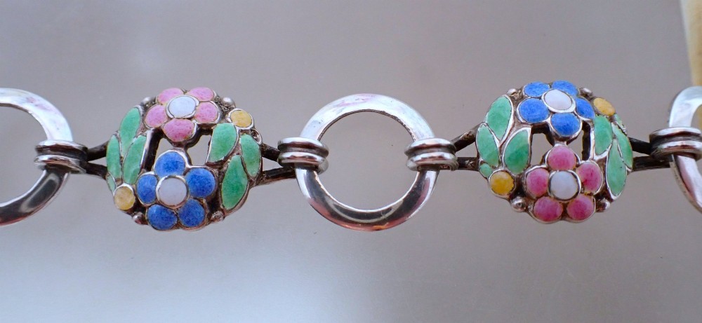 An Arts and Crafts sterling silver link bracelet featuring circular openwork panels decorated with colourful enamelled flowers and leaves. View III