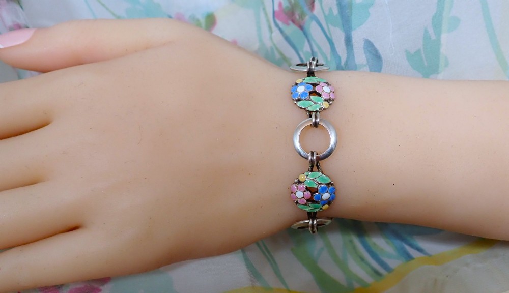 An Arts and Crafts sterling silver link bracelet featuring circular openwork panels decorated with colourful enamelled flowers and leaves. View IV