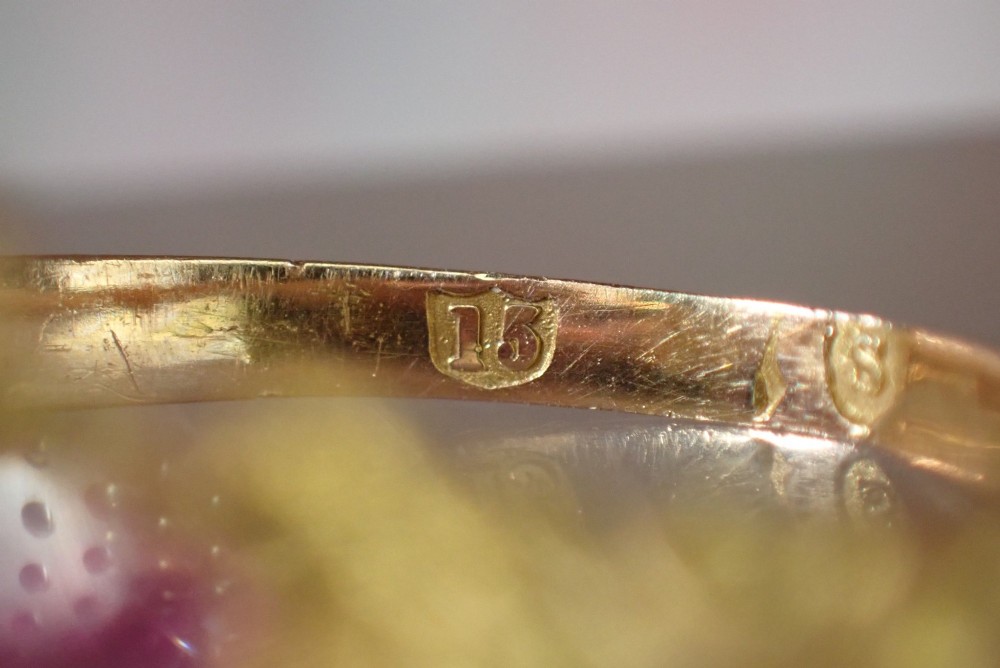 An antique Victorian 15ct yellow gold ring featuring four oval almandine garnets centred around a single old-cut diamond with carved scroll shoulders. View IX