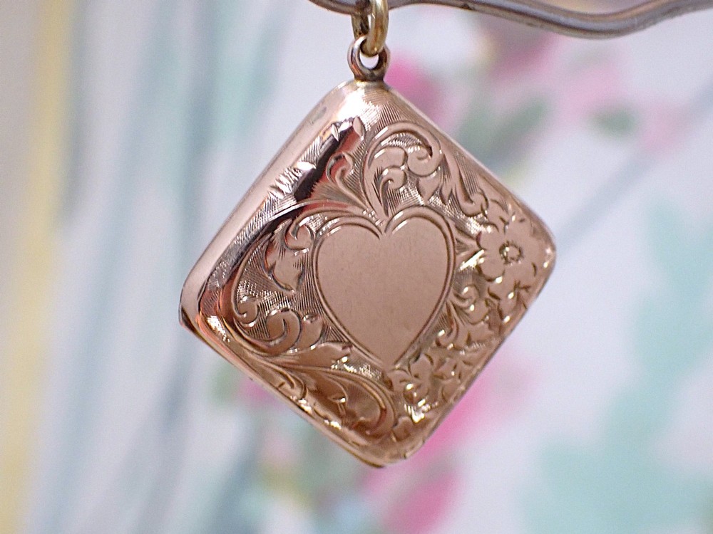 An antique Victorian square rose gold double fronted locket with hand engraved floral patterns and a heart cartouche. View III
