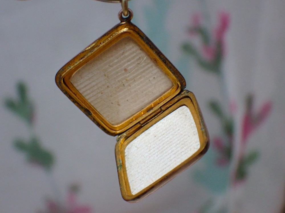 An antique Victorian square rose gold double fronted locket with hand engraved floral patterns and a heart cartouche. View V