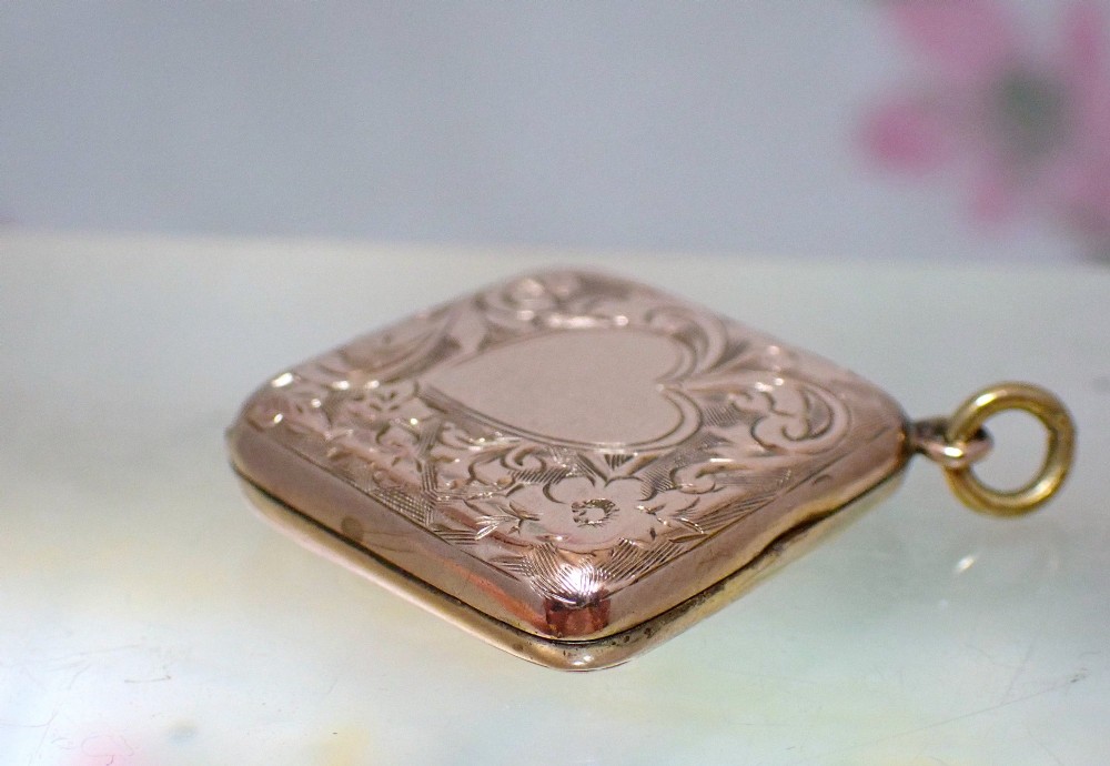 An antique Victorian square rose gold double fronted locket with hand engraved floral patterns and a heart cartouche. View VI