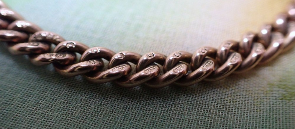 An Edwardian 9ct rose gold curb link bracelet featuring interlocking links and a traditional swivel clasp closure. View III