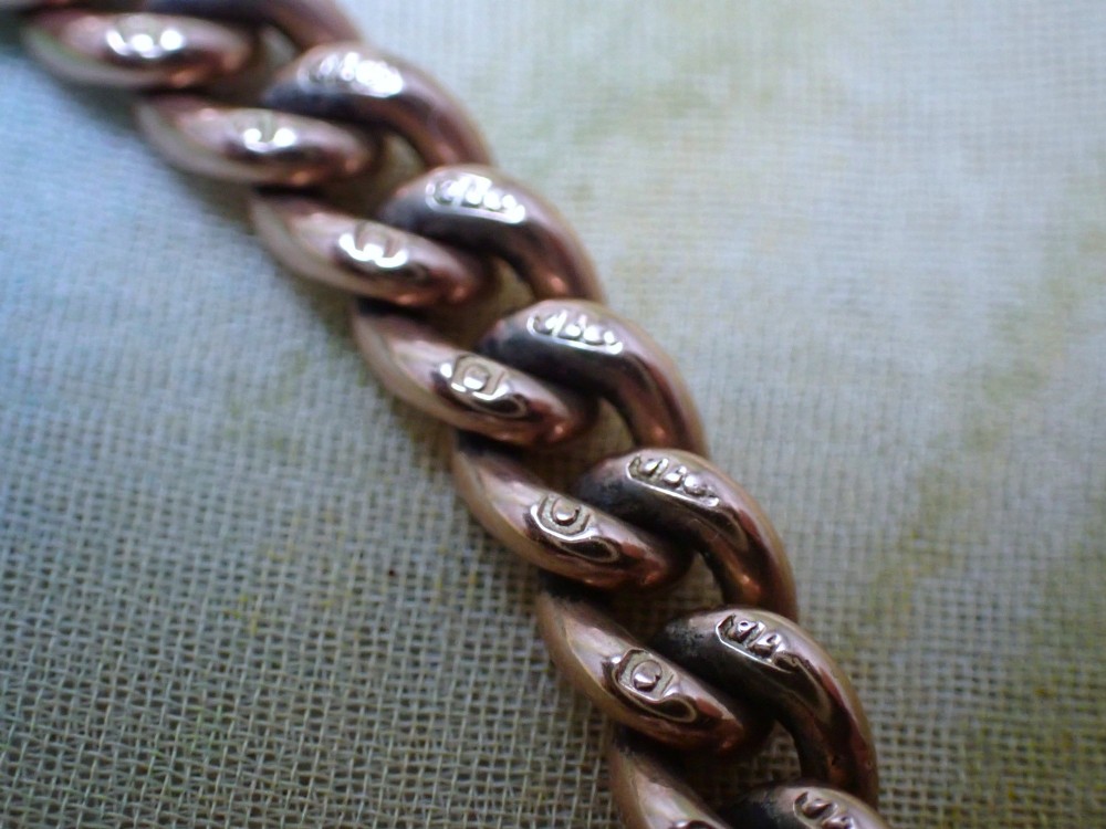 An Edwardian 9ct rose gold curb link bracelet featuring interlocking links and a traditional swivel clasp closure. View V