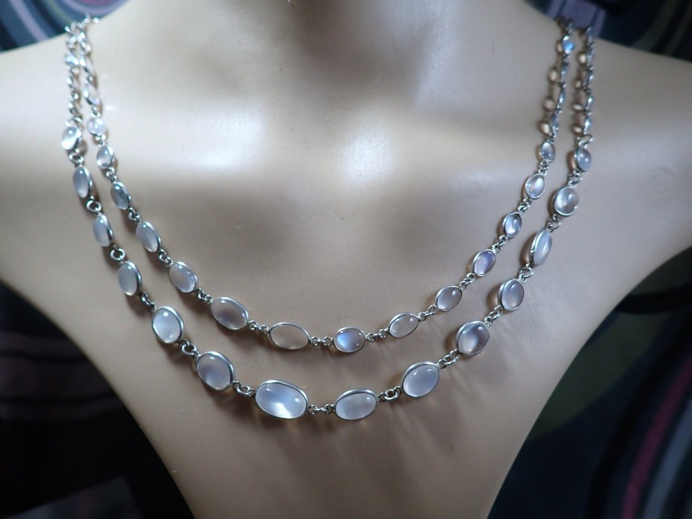 An antique Arts and Crafts sterling silver double-strand necklace featuring bezel-set oval cabochon moonstones linked together by wire chain loops. View IV