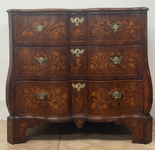 fig 1. An eighteenth-century Dutch walnut chest of drawers featuring shaped drawer fronts with detailed floral marquetry inlays and decorative brass escutcheons.