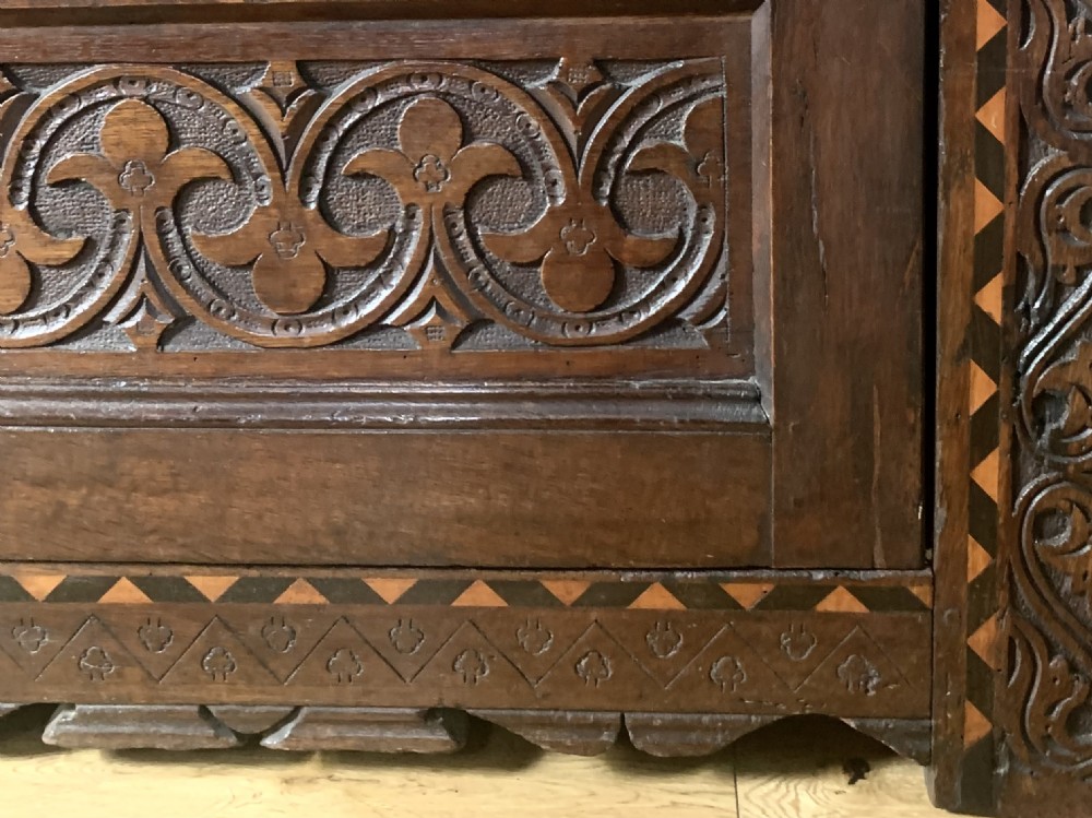 A 17th-century Elizabethan carved oak court cupboard featuring inlaid geometric panels, cup-and-cover supports, and arcaded lower doors. View VII