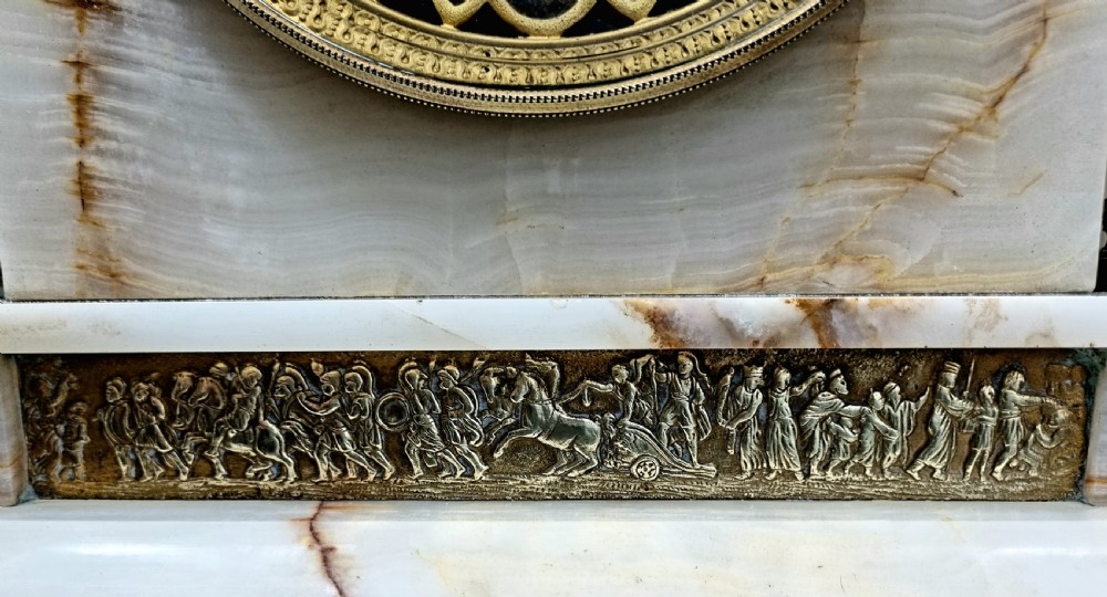 A nineteenth-century cream onyx mantel clock featuring gilt bronze mounts, classical columns, a decorative pierced dial, and a small bust of William Shakespeare mounted at the top. View IV