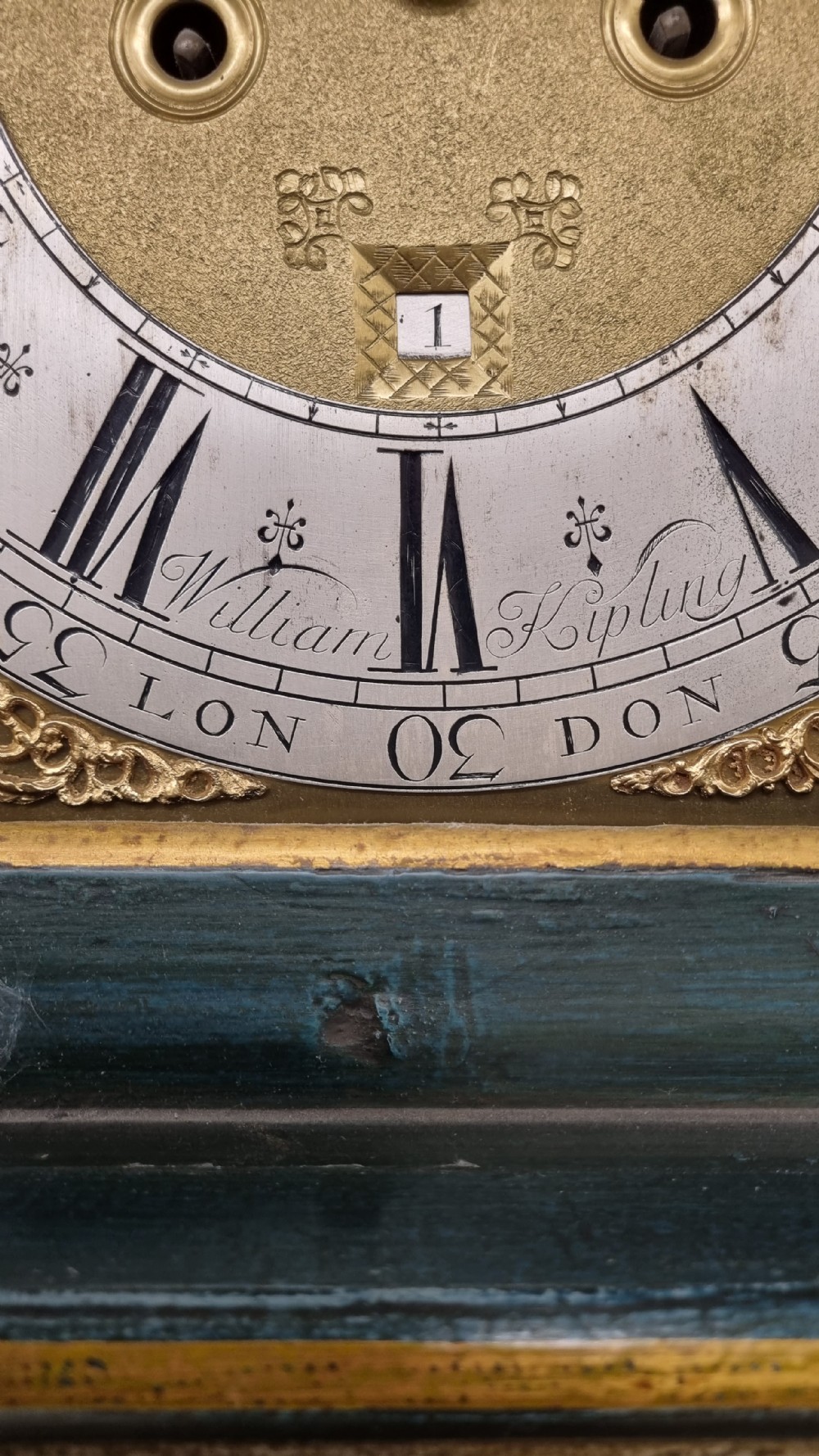 An 18th-century green and gold Japanned longcase clock featuring hand-painted Chinoiserie landscapes, an arched brass dial, and gilt finials. View VII