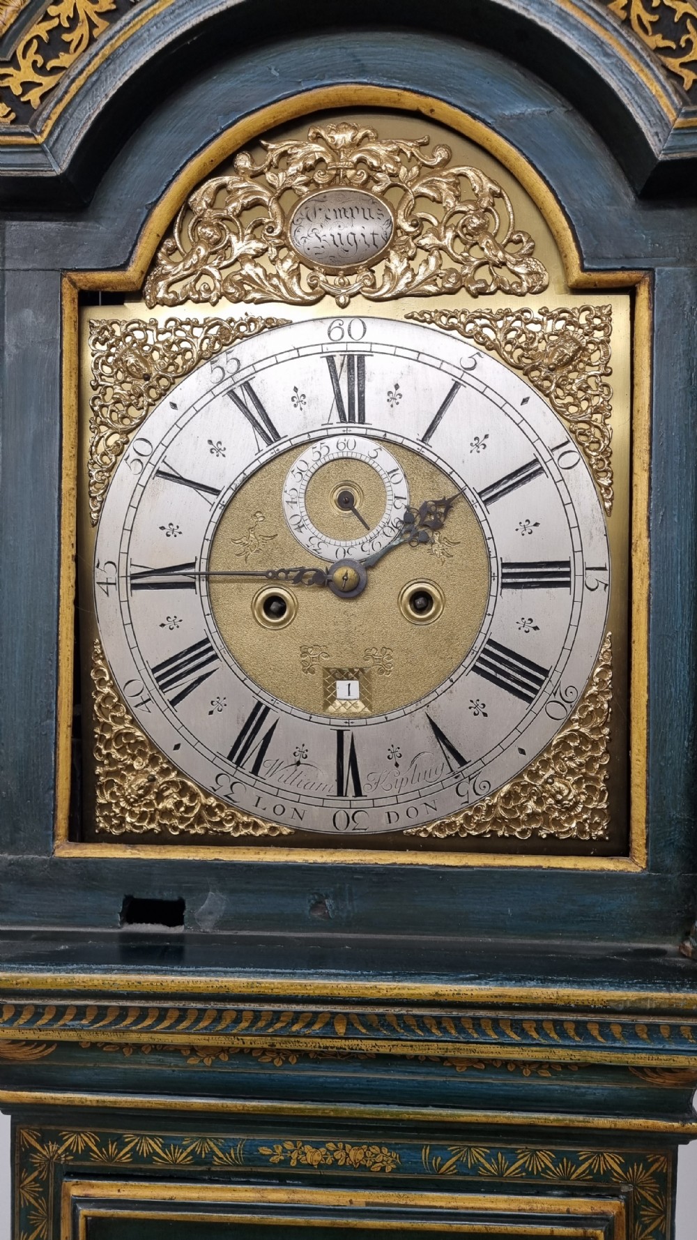 An 18th-century green and gold Japanned longcase clock featuring hand-painted Chinoiserie landscapes, an arched brass dial, and gilt finials. View XVII
