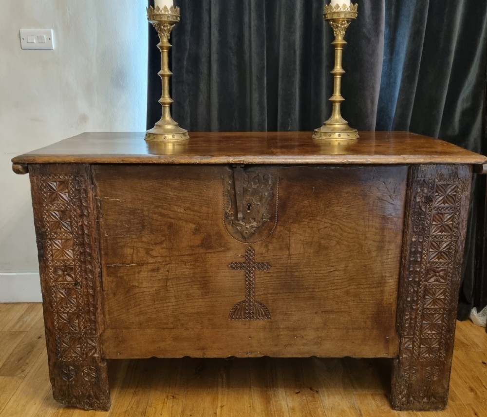 A dark stained oak coffer with carved geometric border panels, a central carved cross design, and a wrought iron escutcheon on the front. View II