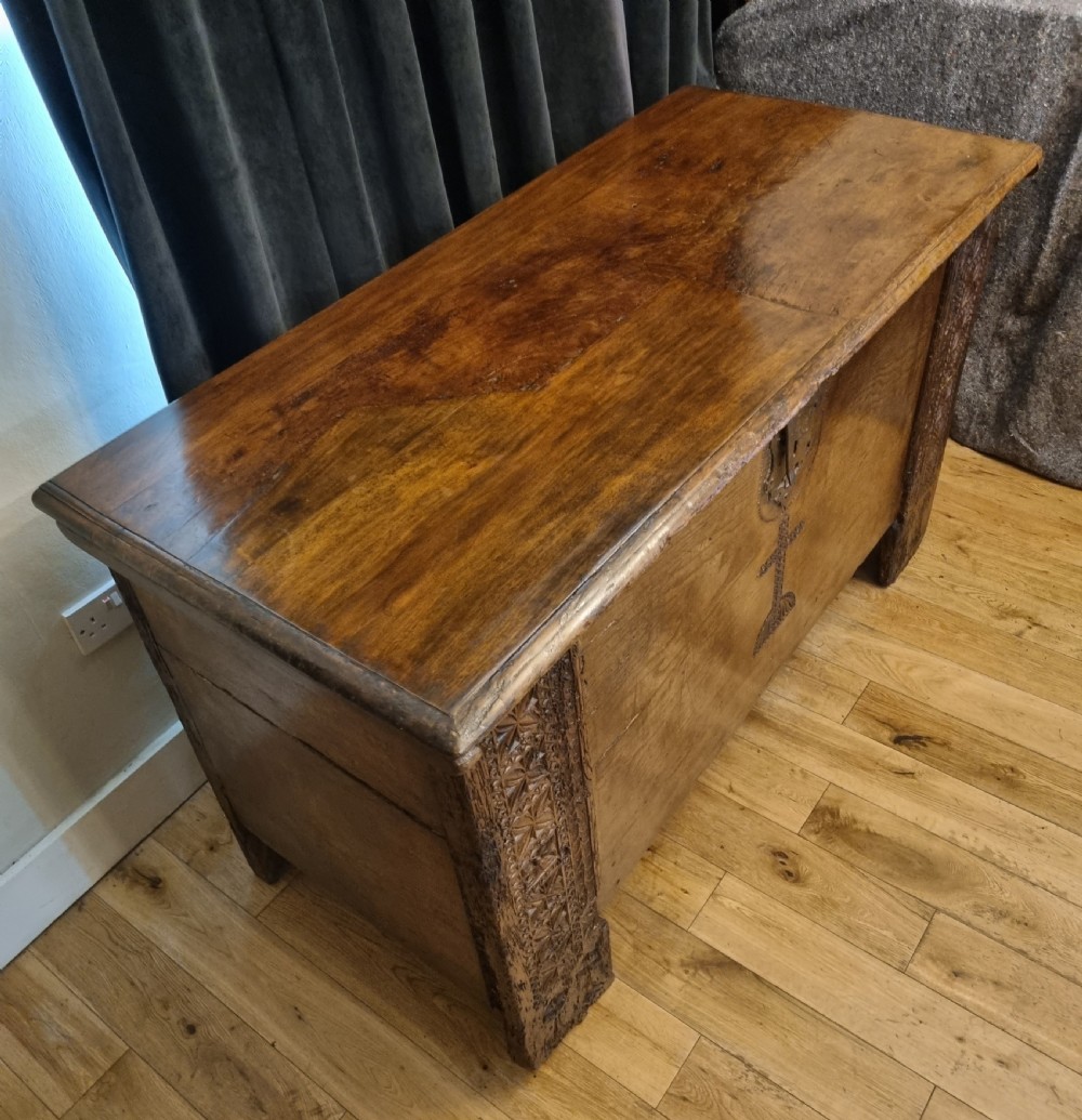 A dark stained oak coffer with carved geometric border panels, a central carved cross design, and a wrought iron escutcheon on the front. View IV