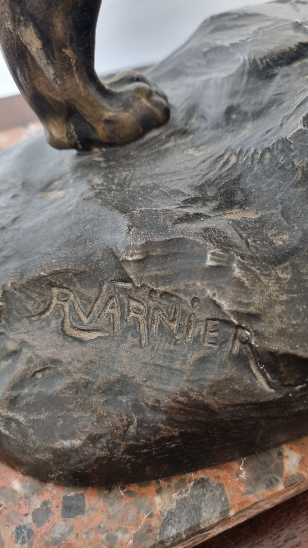 A dark patinated bronze sculpture of a tiger fighting a serpent set upon a rock housing a round clock dial, all resting on a rectangular veined marble base. View XI