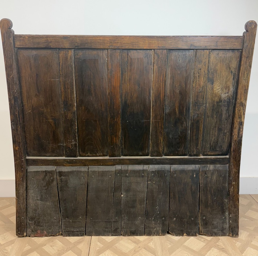 An 18th-century oak and ash box settle featuring a high five-panel back, straight armrests, and a hinged bench seat over a solid storage base. View VII