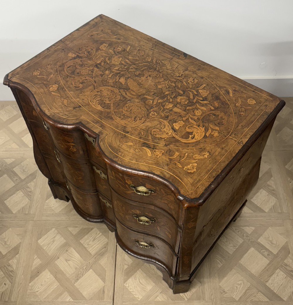 An eighteenth-century Dutch walnut chest of drawers featuring shaped drawer fronts with detailed floral marquetry inlays and decorative brass escutcheons. View VIII