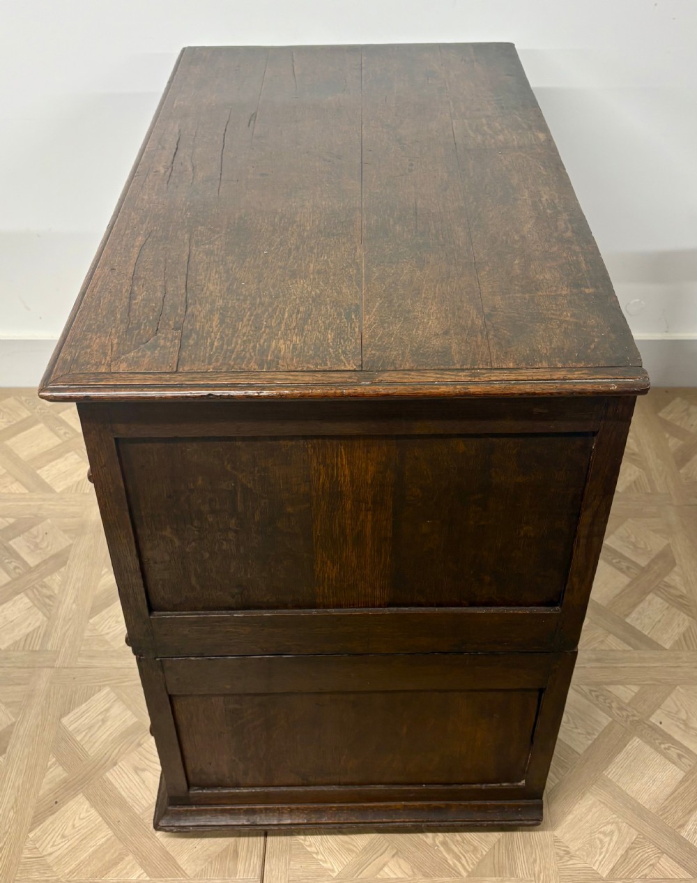 A seventeenth-century dark oak chest of drawers featuring geometric applied mouldings, bobbin detailing, and brass drop handles. View IV